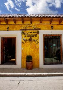 圣克里斯托瓦尔-德拉斯卡萨斯普里马韦拉酒店的黄色的建筑,旁边标有标志