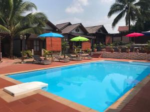 琅勃拉邦通湾旅馆的一座带遮阳伞的房屋前的游泳池