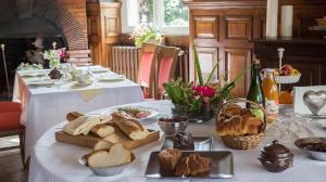 栋弗龙国际之家法兰西酒店的一张桌子,上面有白色的桌布,上面有面包和糕点