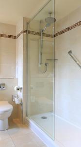 阿维莫尔Macdonald Morlich Hotel at Macdonald Aviemore Resort的带淋浴的浴室和玻璃门