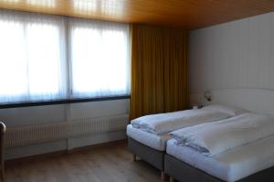 安特里堡Hotel Garni Rösslipost的带2扇窗户的客房内的2张床