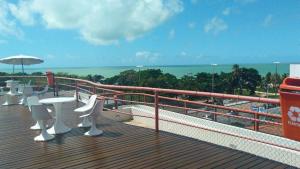 若昂佩索阿Residencial Victory Business Flat的阳台配有桌椅,享有海景。
