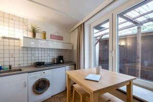 科隆Garden Apartment的厨房配有洗衣机和木桌。