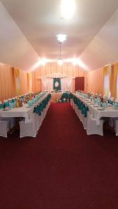 SvitlovodsʼkHotel Tropicana的宴会厅配有白色桌子和绿色椅子