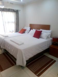 弗朗西斯敦Eros Guest Inn的卧室配有带红色枕头的大型白色床