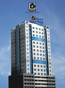 麦纳麦Al Olaya Suites Hotel的一座高大的建筑,上面有标志