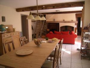 Les IlhesLa Maison du Voyageur的厨房以及带桌子和红色沙发的用餐室。