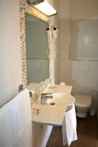 波尔图Hôtel Colombo- Porto Corse的一间带水槽、镜子和卫生间的浴室