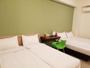 Weiqian享玩民宿的绿墙客房的两张床