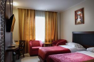 茂物Onih Hotel的酒店客房带两张床、椅子和窗户