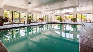 桑迪红棉树贝斯特韦斯特高级酒店的一座大型室内游泳池,位于一座带窗户的建筑中