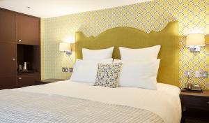 伦敦54皇后门酒店的卧室配有带白色枕头的大床