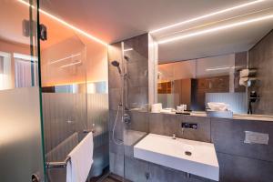 耶拿斯卡拉图姆酒店及餐厅的一间带水槽、淋浴和镜子的浴室