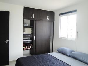 圣罗莎德卡瓦尔Santa Isabel Centro 401的一间卧室配有一张床和一个黑色衣柜