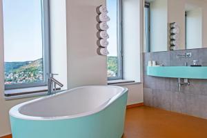 耶拿斯卡拉图姆酒店及餐厅的带浴缸、水槽和窗户的浴室