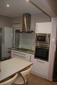 里尔Appt Hotel republique的厨房配有桌子和炉灶。 顶部烤箱
