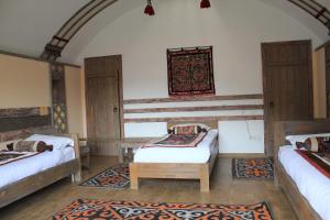 Alamedin卡拉布拉克生态度假酒店的带三张床和地毯的房间