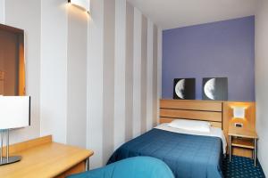 蒙蒂基亚里加尔达酒店的一间卧室设有一张蓝色的床和条纹墙