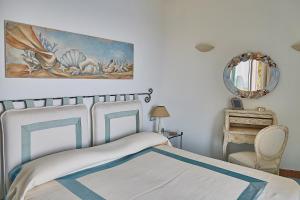 卡普里Residence Leonardo的卧室配有一张床,墙上挂有绘画作品