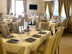 恩佩多克莱港Hotel Riviera Palace的用餐室配有桌椅和白色的桌布