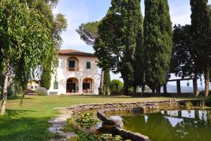 因普鲁内塔"Alle Montanine" Villa Poggio的前面有池塘的大房子