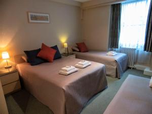 伦敦欧罗酒店的两张位于酒店客房的床,配有毛巾