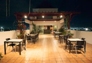 马尼拉尼可尔斯机场酒店的晚上在阳台上设有桌椅的餐厅