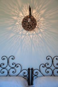 奥特朗托马赛利亚蒙特劳洛酒店的挂在床上的吊灯,有白色的墙壁