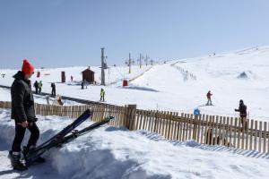 科维良Luna Hotel Serra da Estrela的站在雪中滑雪板围栏旁的人