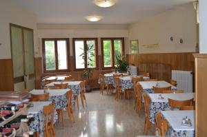Vaglia帕德里诺酒店的用餐室设有桌椅和窗户。