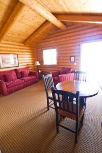 科迪科迪牛仔村酒店的客厅配有红色的沙发和桌子