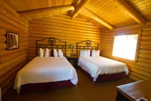 科迪科迪牛仔村酒店的小木屋内一间卧室,配有两张床