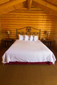 科迪科迪牛仔村酒店的卧室配有白色的木墙床