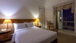 科英布拉阿斯托利亚酒店的卧室设有一张白色大床和一扇窗户。