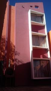 卡拉马Hotel Don Alfredo的粉红色和白色的建筑,有很多窗户