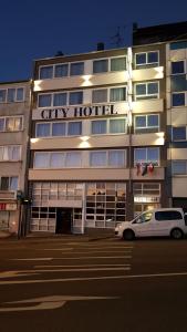 伍珀塔尔City Hotel Wuppertal的停在城市酒店前的白色汽车