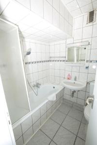 伍珀塔尔City Hotel Wuppertal的白色的浴室设有浴缸和水槽。