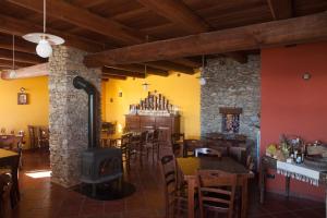 Ostana阿诺斯拓米宗农家乐的一间带桌椅和燃木炉的餐厅