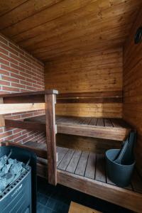 TölväJokiniemen Matkailu Cottages的木制桑拿浴室设有长凳和炉灶