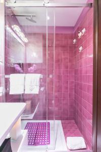 罗马戴安娜豪华阁楼公寓的粉红色的瓷砖浴室设有淋浴和盥洗盆