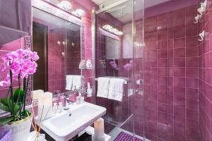 罗马戴安娜豪华阁楼公寓的粉红色的浴室设有水槽和镜子