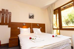 Kolarovo圣内德亚酒店的卧室配有一张大白色的玫瑰床