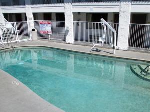 弗雷斯诺行政旅馆的一座带椅子的建筑前的游泳池