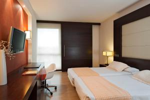 波苏埃洛-德阿拉尔孔欧洲之星马德里酒店的配有一张床和一张书桌的酒店客房