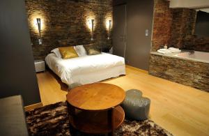 里昂古尔林恩酒店的一间卧室配有一张床、一张桌子和一个浴缸