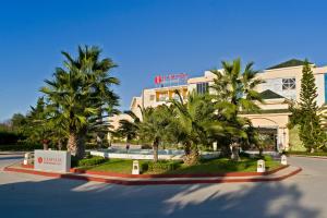 迦玛特Ramada Plaza by Wyndham Tunis的一座楼前有棕榈树的酒店