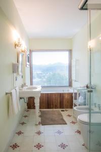 圣马丁德洛斯Paraíso Casa de Montaña的一间带水槽和浴缸的浴室以及窗户。
