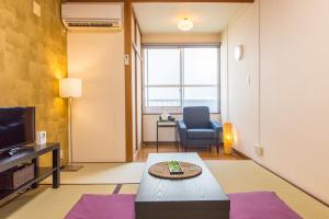 金泽阳光高地度假租赁酒店的带沙发、桌子和电视的客厅