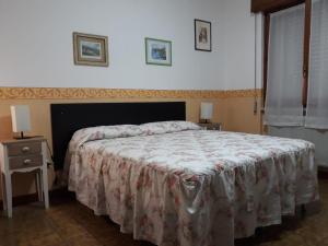 伦德吉安格洛住宿加早餐旅馆的一间卧室配有一张带花卉床罩和床头柜的床。