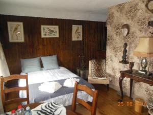 Corroy-le-ChâteauAu trou perdu的一间卧室设有一张床和木墙